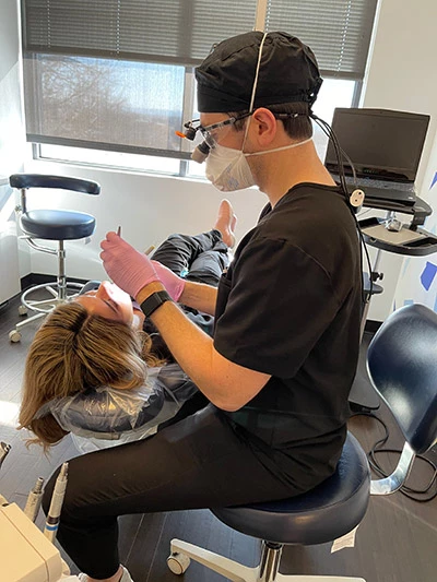 Dental hygienist assisting a patient with a dental cleaning
